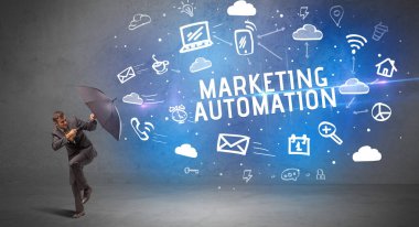 MARKETING AUTOMATION yazıtlarından şemsiyeyle savunma yapan iş adamı, modern teknoloji kavramı