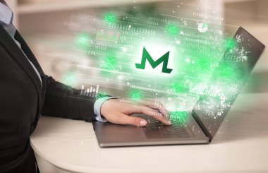 Dizüstü bilgisayarda borsayı izleyen genç adam monero simgeleri, forx konsepti