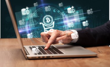 İşadamı, bilgisayar ekranından çıkan bitcoin simgeleriyle birlikte borsada çalışıyor.