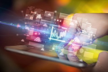 Grafik simgeleri içeren tablet kullanan bir elin yakın plan görüntüsü, dijital para birimi kavramı