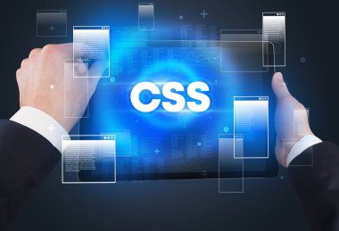 CSS kısaltmalı, modern teknoloji kavramlı el ele tutuşma tabletinin yakın çekimi