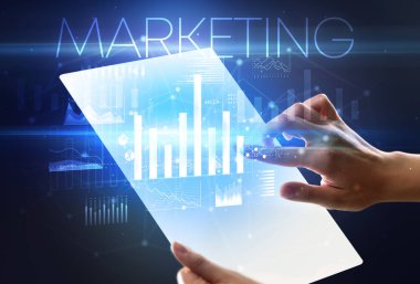 Üzerinde MARKETING yazıtları olan el ele tutuşan fütürist tablet, modern iş kavramı