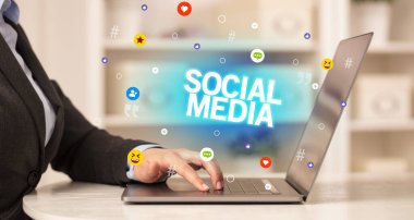 SOSYAL MEDIA yazıtlı, Sosyal medya konseptli dizüstü bilgisayar kullanan serbest çalışan kadın