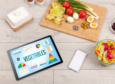 Organik gıda ve tablet bilgisayarı VEGETABLES yazısını, sağlıklı beslenme bileşimini gösteriyor