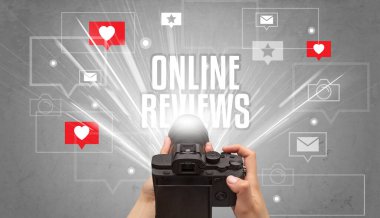 ONLINE REVIEWS yazıtları, sosyal medya kavramı ile fotoğraf çeken bir elin yakın çekimi