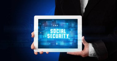 Tablet üzerinde çalışan genç iş adamı dijital işareti gösteriyor: SOSYAL GÜVENLİK