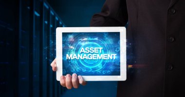 Tablet üzerinde çalışan genç iş adamı ve yazıyı gösteriyor: ASSET MANAGEMENT, iş konsepti