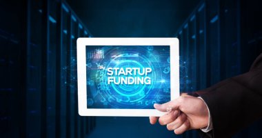 Tablet üzerinde çalışan genç iş adamı ve yazıyı gösteriyor: STARTUP FUNDING, iş konsepti