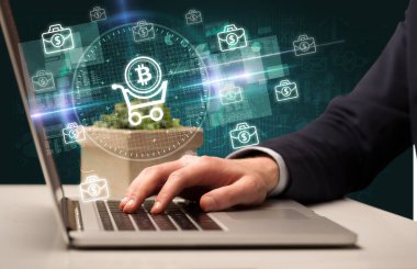 İşadamı, bilgisayar ekranından çıkan bitcoin simgeleriyle birlikte borsada çalışıyor.