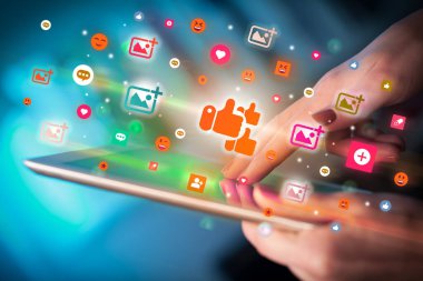 Renkli benzeri simgeler içeren tablet kullanan bir elin yakın plan görüntüsü, sosyal ağ konsepti