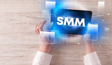 SMM kısaltmalı el ele tutuşma tabletinin yakın çekimi, modern teknoloji kavramı