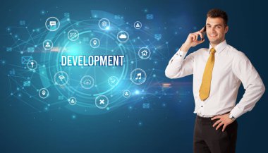 Teknolojiyle ilgili ikonlar ve DEVELOPMENT yazıtları ve modern teknoloji kavramı önünde düşünen iş adamı