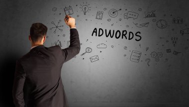 İş adamı ADWORDS yazıtları ve iş stratejisi konseptiyle yaratıcı bir fikir taslağı çiziyor.