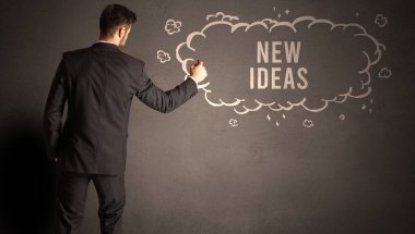 İş adamı içinde NEW IDEAS yazıları olan bir bulut çiziyor, modern iş konsepti.