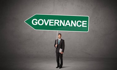 GOVERNANCE yazıtları, yeni iş yönü konsepti ile günlük bekleme yolu tabelasında genç iş adamı