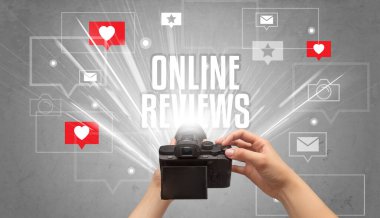 ONLINE REVIEWS yazıtları, sosyal medya kavramı ile fotoğraf çeken bir elin yakın çekimi