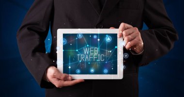 Tablet üzerinde çalışan genç iş adamı dijital işareti gösteriyor: WeB TRAFFIC