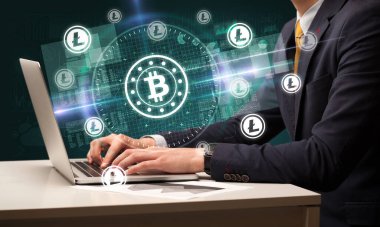 Borsada çalışan iş adamı dizüstü bilgisayardan çıkan bitcoin simgeleriyle