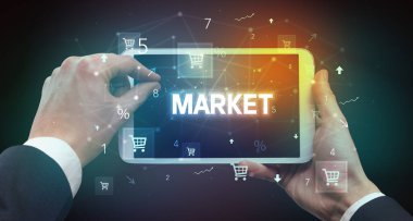 MARKET yazısıyla el ele tutuşma tabletinin yakın çekimi, çevrimiçi alışveriş kavramı