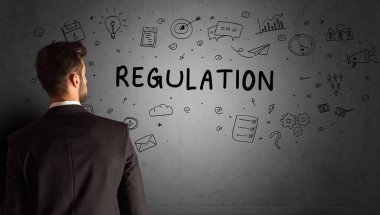 İş adamı, REGULATION yazıtları ve iş stratejisi konseptiyle yaratıcı bir fikir çizimi yapıyor.