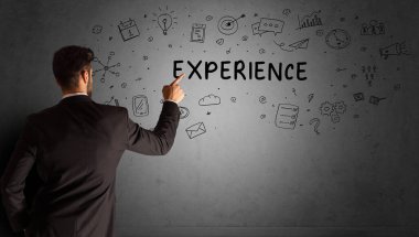 İş adamı, ExperIENCE yazıtları ve iş stratejisi konseptiyle yaratıcı bir fikir çizimi yapıyor.