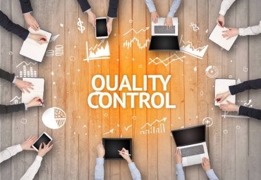 KALİTİLİK KONTROL yazıtları olan bir ofiste çalışan Meşgul İnsanlar Grubu, başarılı iş kavramı