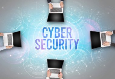 Bir dizüstü bilgisayarın önünde CYBER GÜVENLİK içgüdü, web güvenlik kavramı olan bir grup insan
