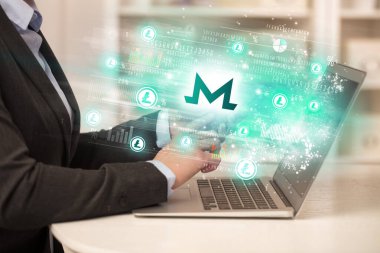 Dizüstü bilgisayarda borsayı izleyen genç adam monero simgeleri, forx konsepti