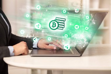 Dizüstü bilgisayarda hisse senedi piyasasını izleyen genç adam bitcoin tasarruf simgeleri, forx konsepti