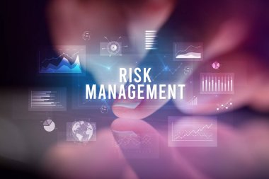Tablete çizelgeler ve RISK MANAGEMENT yazıtları ile dokunmak, iş konsepti