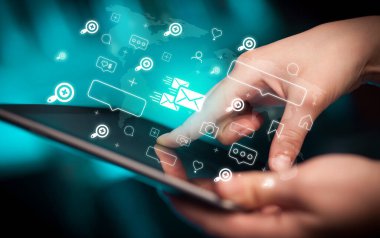 Mesajlaşma simgeleri içeren tablet kullanan bir elin yakın plan görüntüsü, sosyal medya kavramı