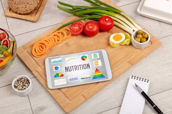 Organik gıda ve tablet bilgisayarı NUTRITION yazısını, sağlıklı besin bileşimini gösteriyor