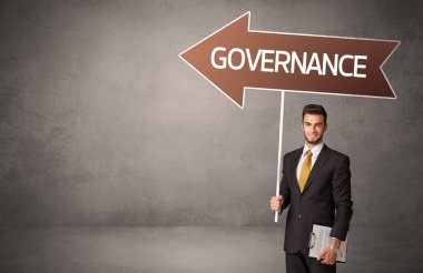 GOVERNANCE yazıtları, iş yönü konsepti ile günlük bekleme yolu tabelasında genç iş adamı