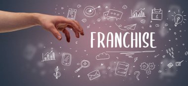 FRANCHISE yazıtına işaret eden kırpılmış elin yakın çekimi, modern iş çözümü kavramı