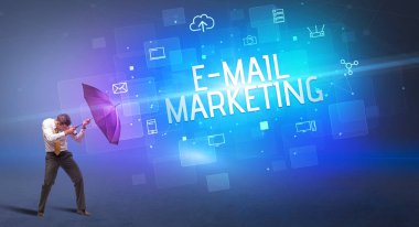 Siber saldırıya karşı şemsiyeyle savunma yapan iş adamı ve e-mail MarkeTING yazısı, çevrimiçi güvenlik kavramı