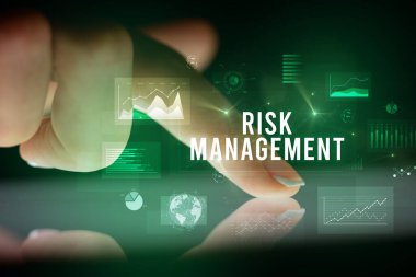 Tablete çizelgeler ve RISK MANAGEMENT yazıtları ile dokunmak, iş konsepti