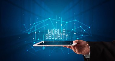 Tablet üzerinde çalışan genç iş adamı dijital işareti gösteriyor: MOBILE GÜVENLİK