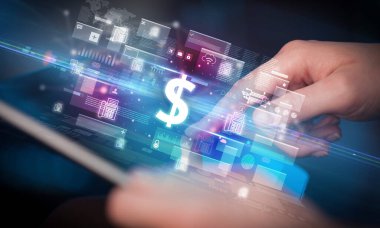 Dolar simgeleri içeren tablet kullanan bir elin yakın çekimi, dijital para birimi kavramı
