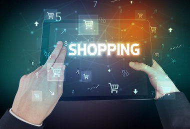 Alışveriş yazıtları ve online alışveriş konseptiyle el ele tutuşma tabletinin yakın çekimi