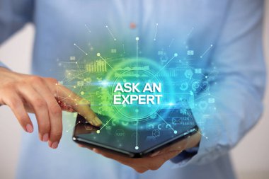 İş adamı elinde katlanabilir bir akıllı telefon tutuyor. Üzerinde Ask A Expert yazıları ve yeni iş konsepti var.