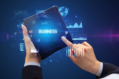 İş adamı elinde katlanabilir bir akıllı telefon tutuyor. İş dünyası yazıtları, başarılı bir iş konsepti.