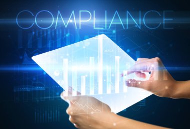 Üzerinde COMPLIANCE yazıtları olan el ele tutuşan fütürist tablet, modern iş konsepti