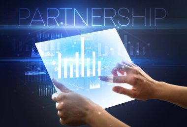 Üzerinde PARTNERGeIP yazıtları olan el ele tutuşma tableti, modern iş konsepti
