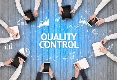 KALİTİLİK KONTROL yazıtları olan bir ofiste çalışan Meşgul İnsanlar Grubu, başarılı iş kavramı