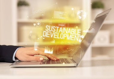 Diz üstü bilgisayarda çalışan bir iş adamının yan görünüşü SuSTAINable DEVELOPMENT yazıtları, modern iş konsepti