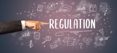 Kesilmiş ellerin yakın çekimi REGULATION yazıtlarına işaret ediyor, modern iş çözümleri kavramı