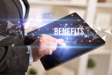 BENEFITS yazıtları ve modern iş teknolojisi kavramı olan tablet kullanarak elleri kapat