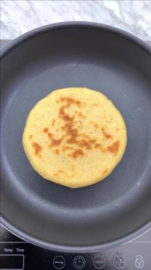 Sıcak bir tencerede arepa ya da tortilla yapmak..