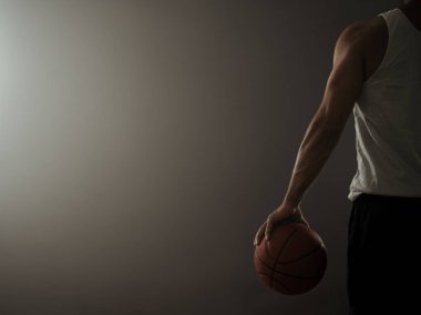 Boş spor salonunda fotokopi alanı olan bir basketbolcunun arka görünümü