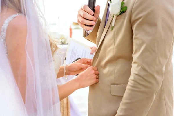 stock image The bride straightens the groom's jacket during wedding ceremony.